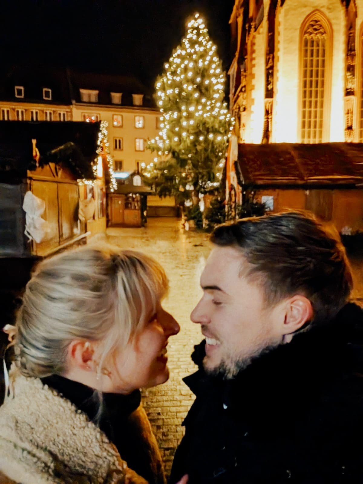 Beide auf dem Weihnachtsmarkt vor dem beleuchteten Baum