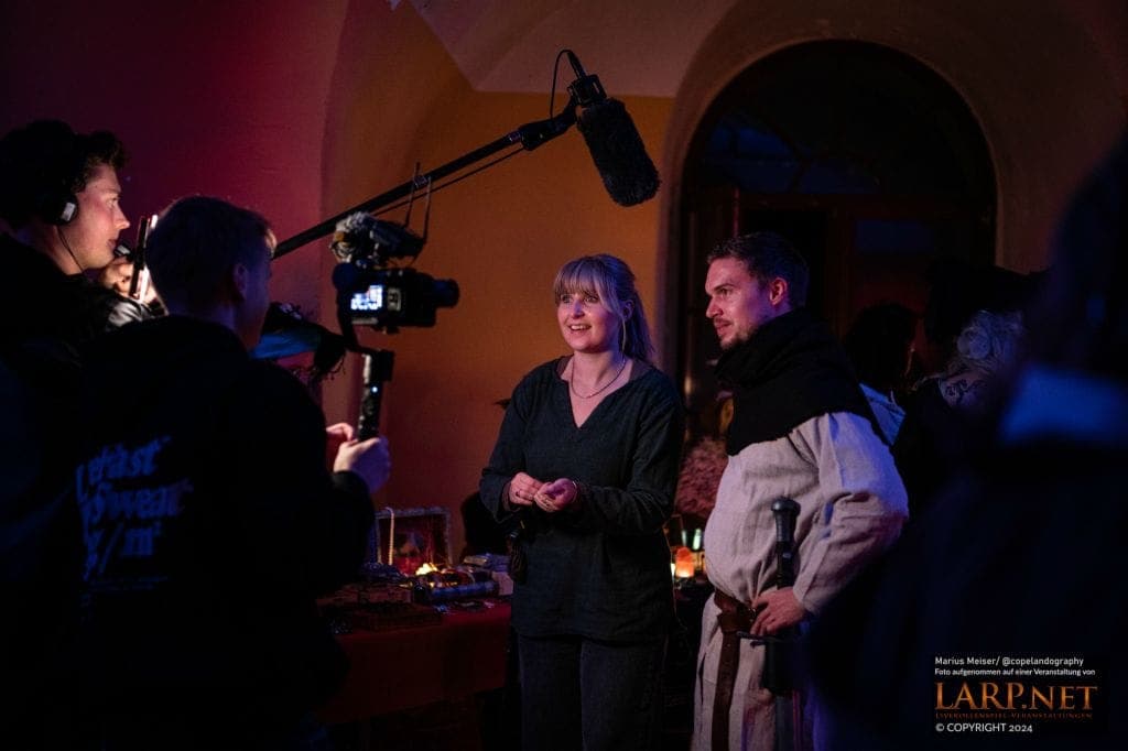 Beide im Kostüm vor einem Filmteam beim LARP-Event