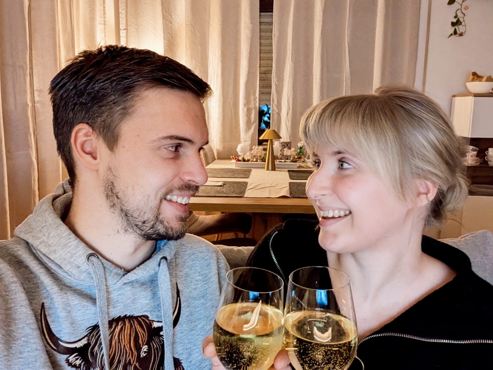 Anstoßen mit Sekt auf dem Sofa